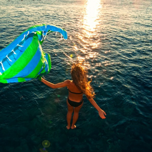 girl diving into sea with a brightly coloured Hammamas towel