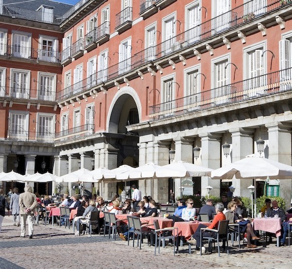 people sitting at cafes at the plaza Mayor Madrid
